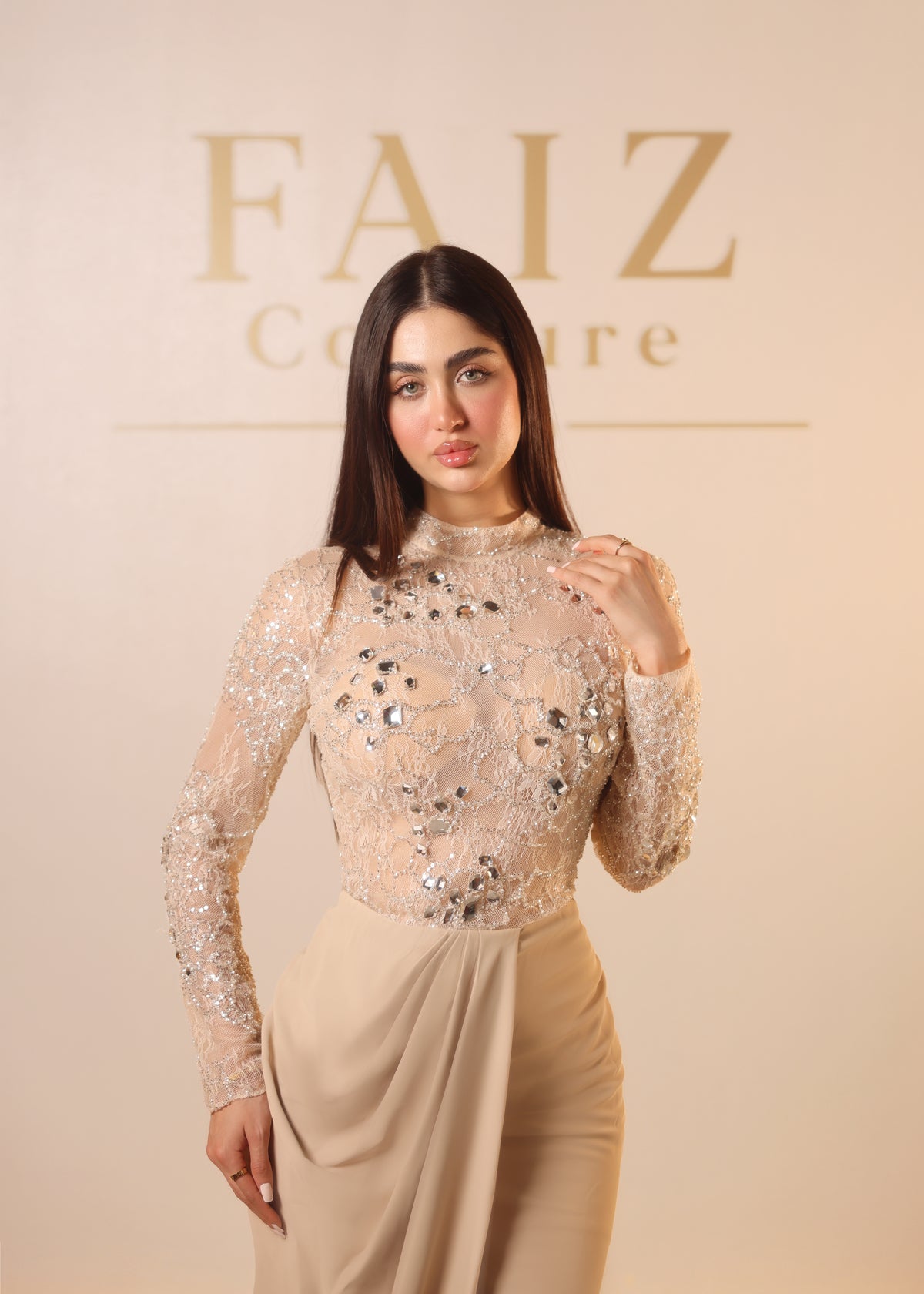 A woman modeling a beige long-sleeve embellished lace top and matching draped skirt FAIZ COUTURE